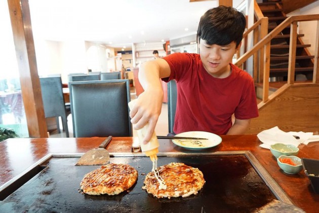 man making okonomiyaki at Nanjya Monjya japanese restaurant