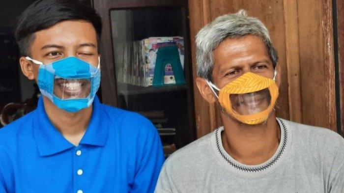 Two men wear masks designed by Dwi