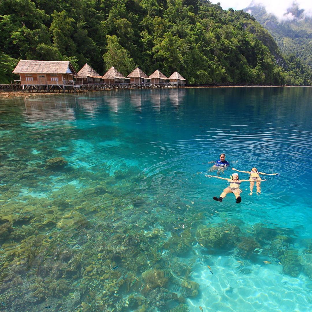 Three people at Ora Beach, Central Maluku