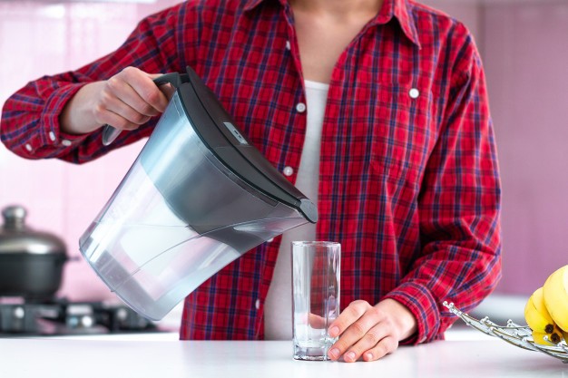 woman pouring water into glass