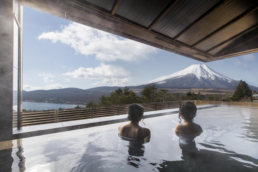 Communal outdoor hot spring bath with a view of the mountain.