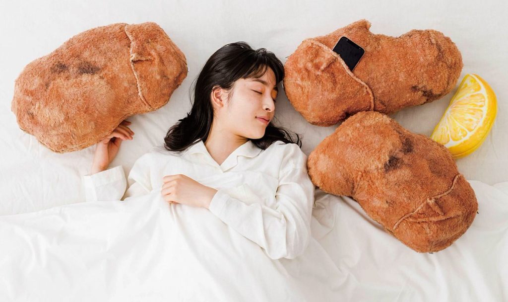 Felissimo’s karaage cushions - woman lying on a bed with karaage ad lemon cushion