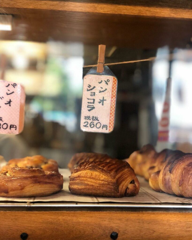 Bakeries in Hokkaido - at Marumugi, A daily selection of bread is displayed on the wooden bread shelf that’s adjacent to the entrance