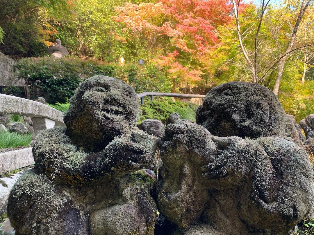 Otagi Nenbutsu-ji - a pair of rakan statues sharing a good laugh over wine