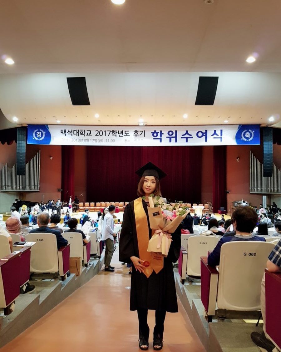 korean idol university majors - Minzy at her graduation ceremony in 2018