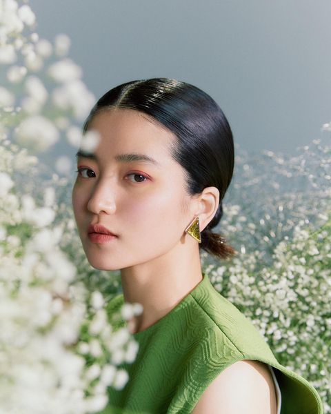 kim taeri facts - kim taeri in a photoshoot surrounded by flowers while wearing a green shirt