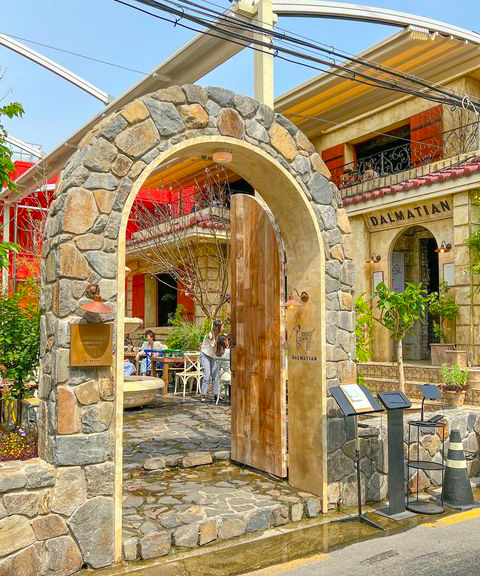 Dalmatian - A stone archway leads into a cobbled courtyard of the cafe 