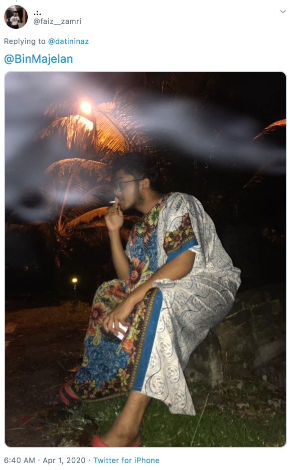 Man smokes in a baju M'sian men wear baju kelawar