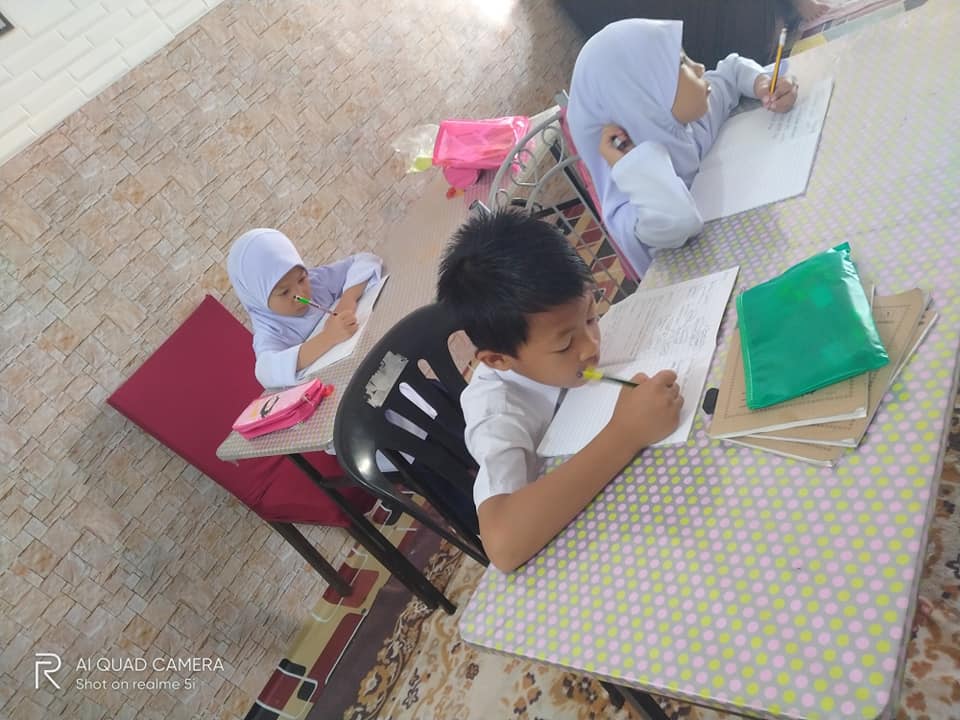 Nur Salina's kids writing notes on their desk