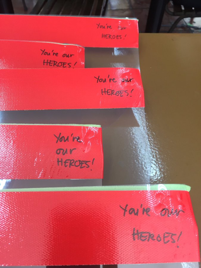 red strips of tape with handwritten "You are our heroes"