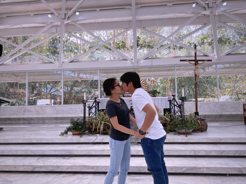 couple in shirts and jeans kissing