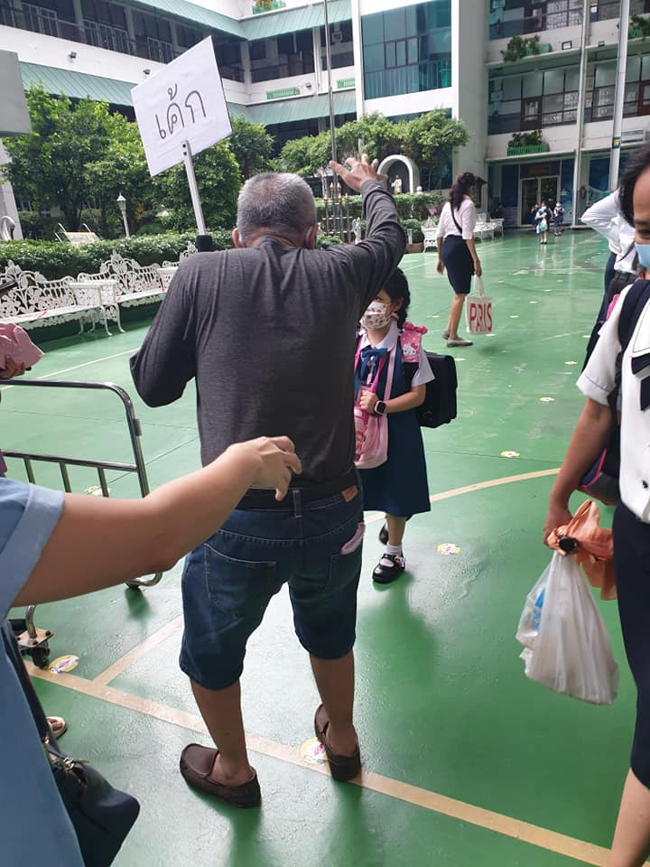 Thai grandpa makes a sign to pick up the right kid