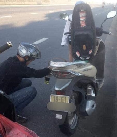 Vietnamese man offers gasoline to stranger_removing gasoline from his own motorbike