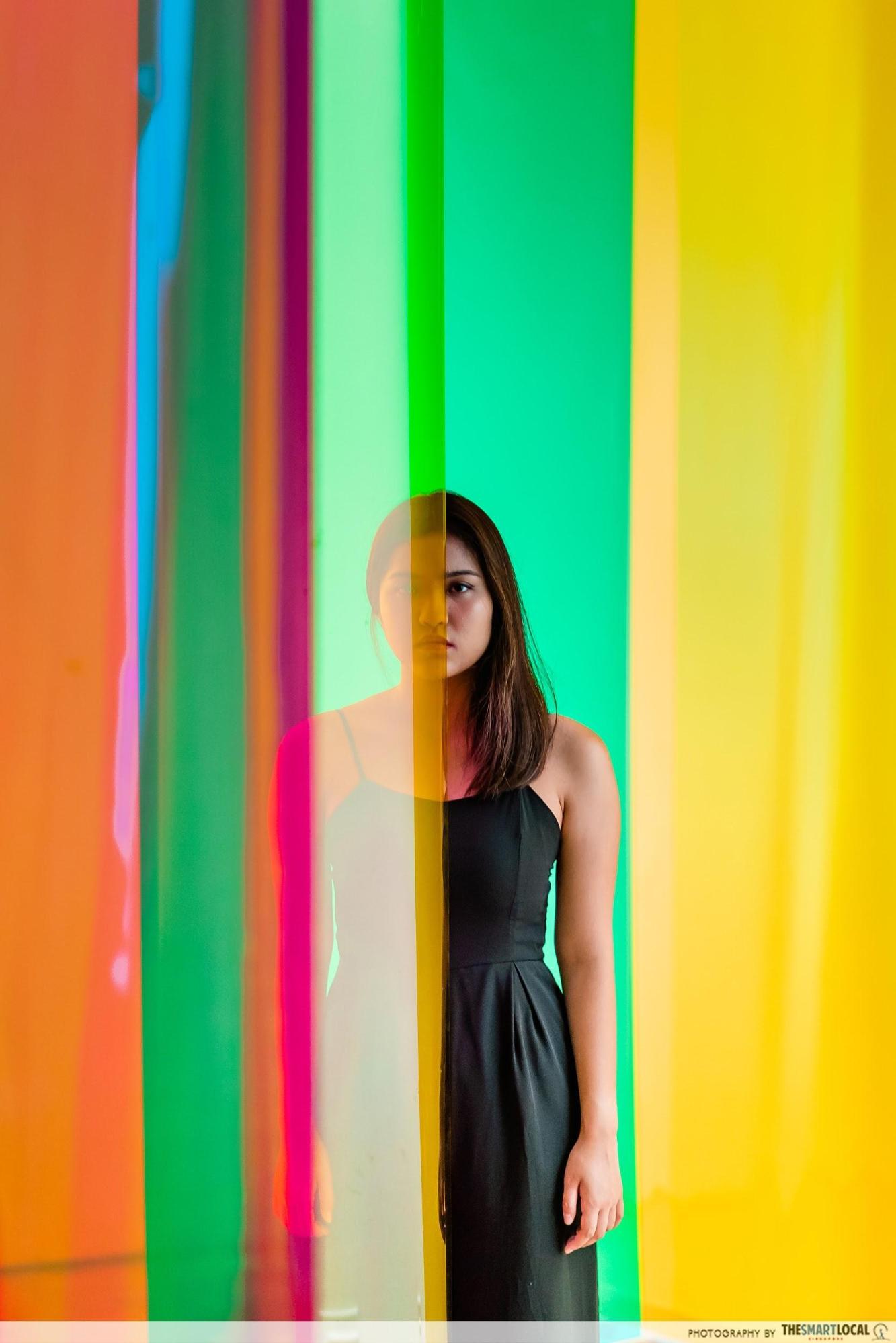 model standing between translucent colored sheets