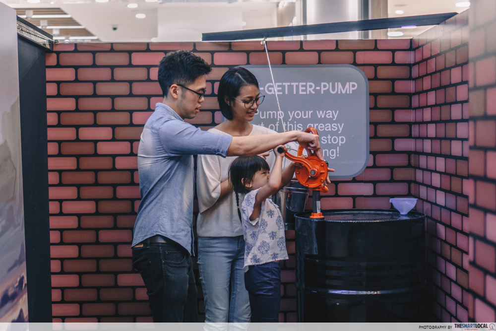 Father, mother and daughter doing pumping oil activity