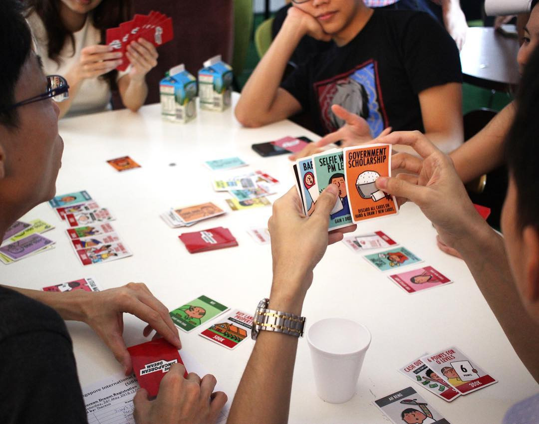 people playing card games the singapoean dream friends gathering