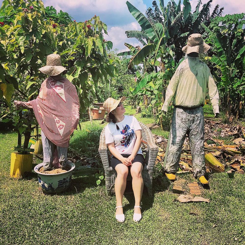 Lady between 2 scarecrows