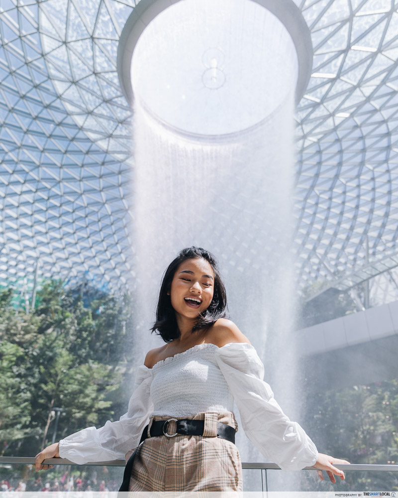 Girl posing in front of Rain Vortex at Jewel Changi