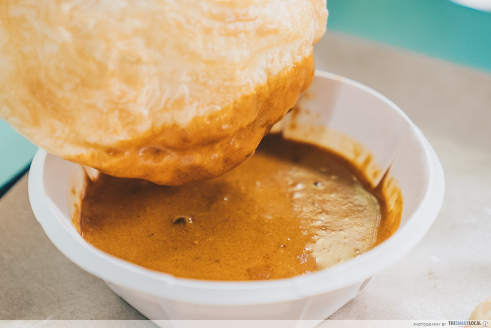 dipping baked prata into curry