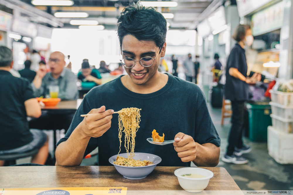 man eating a bowl of truffle wanton mee