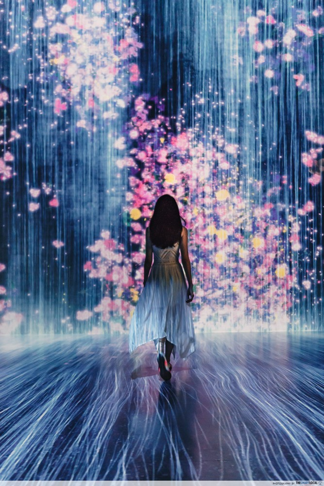 Image of woman standing in front of light projections at the Future World exhibit
