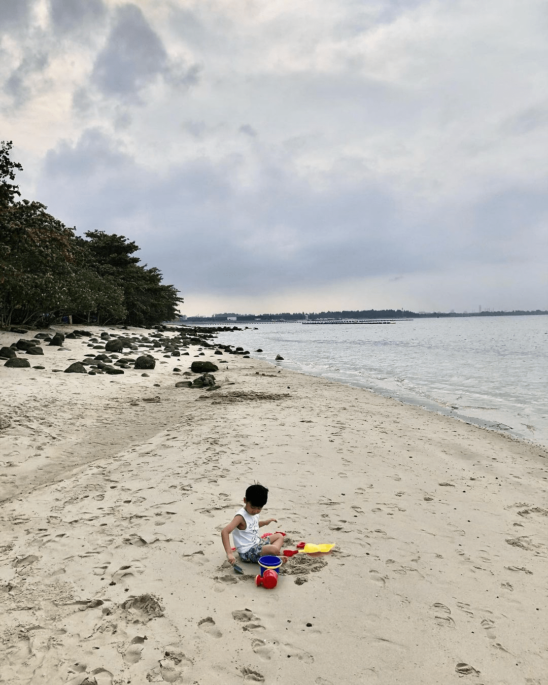 Child playing with the sand on Punggol Beach