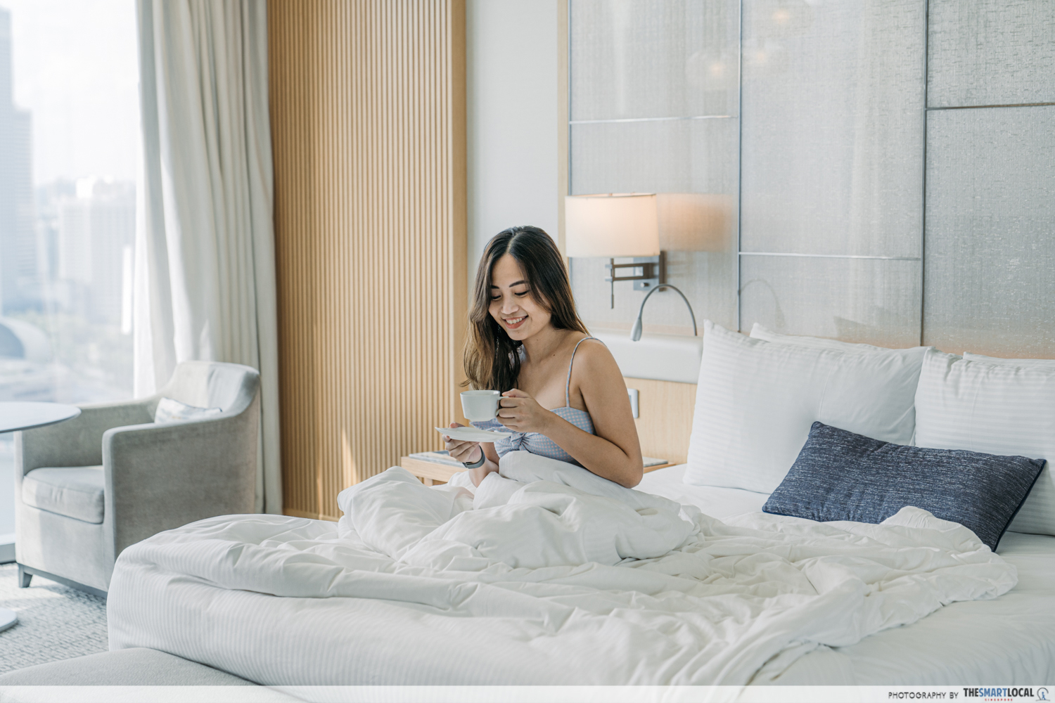 Girl having a staycation in bed at MBS hotel