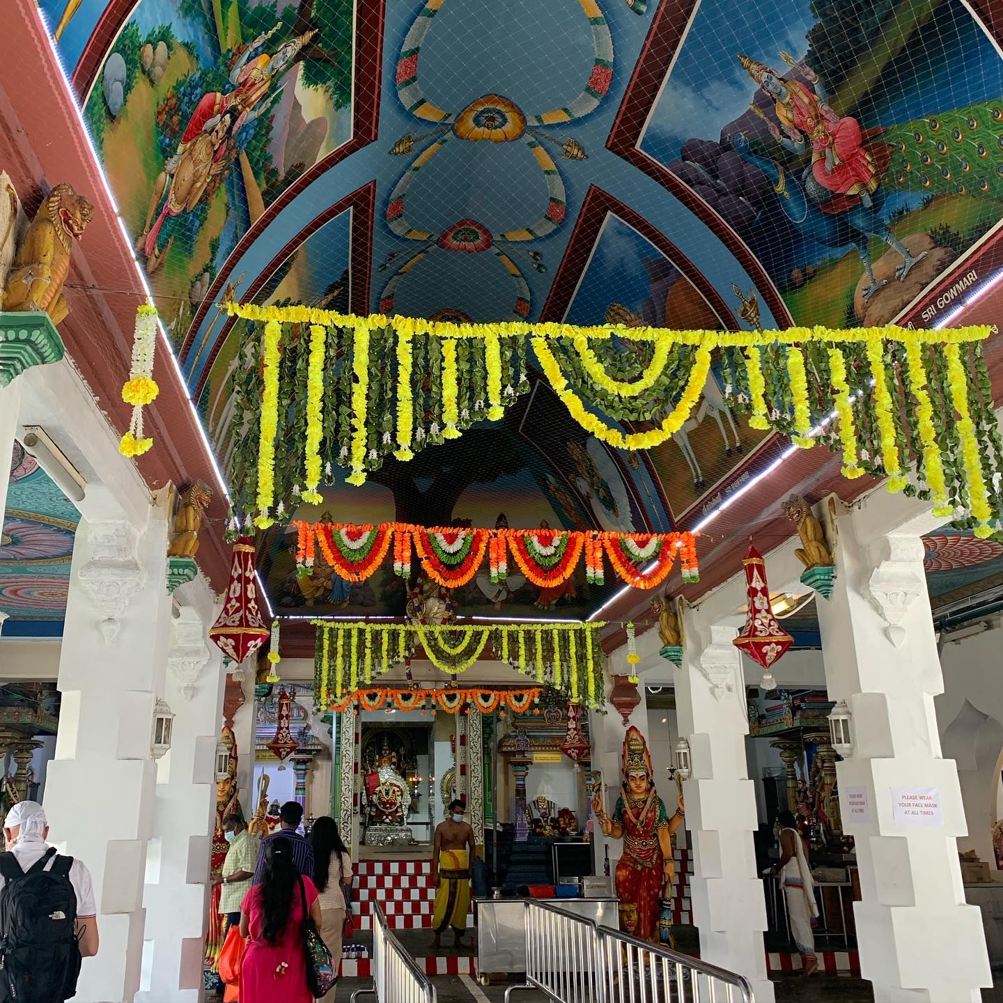  an indoor view of sri mariamman temple decorated with ceiling frescos and flowers