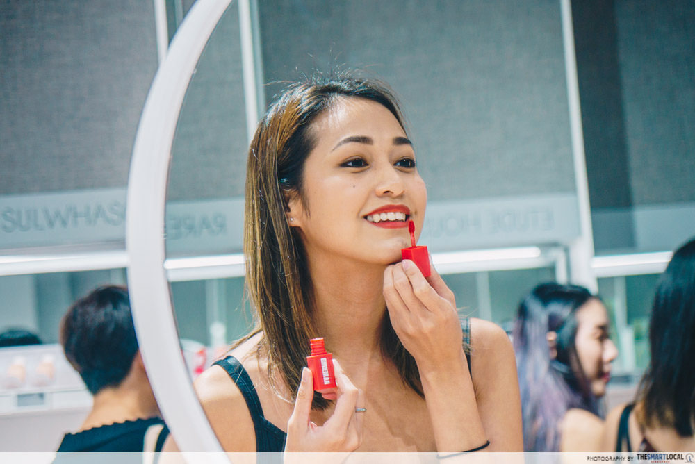 Applying red lipstick in mirror