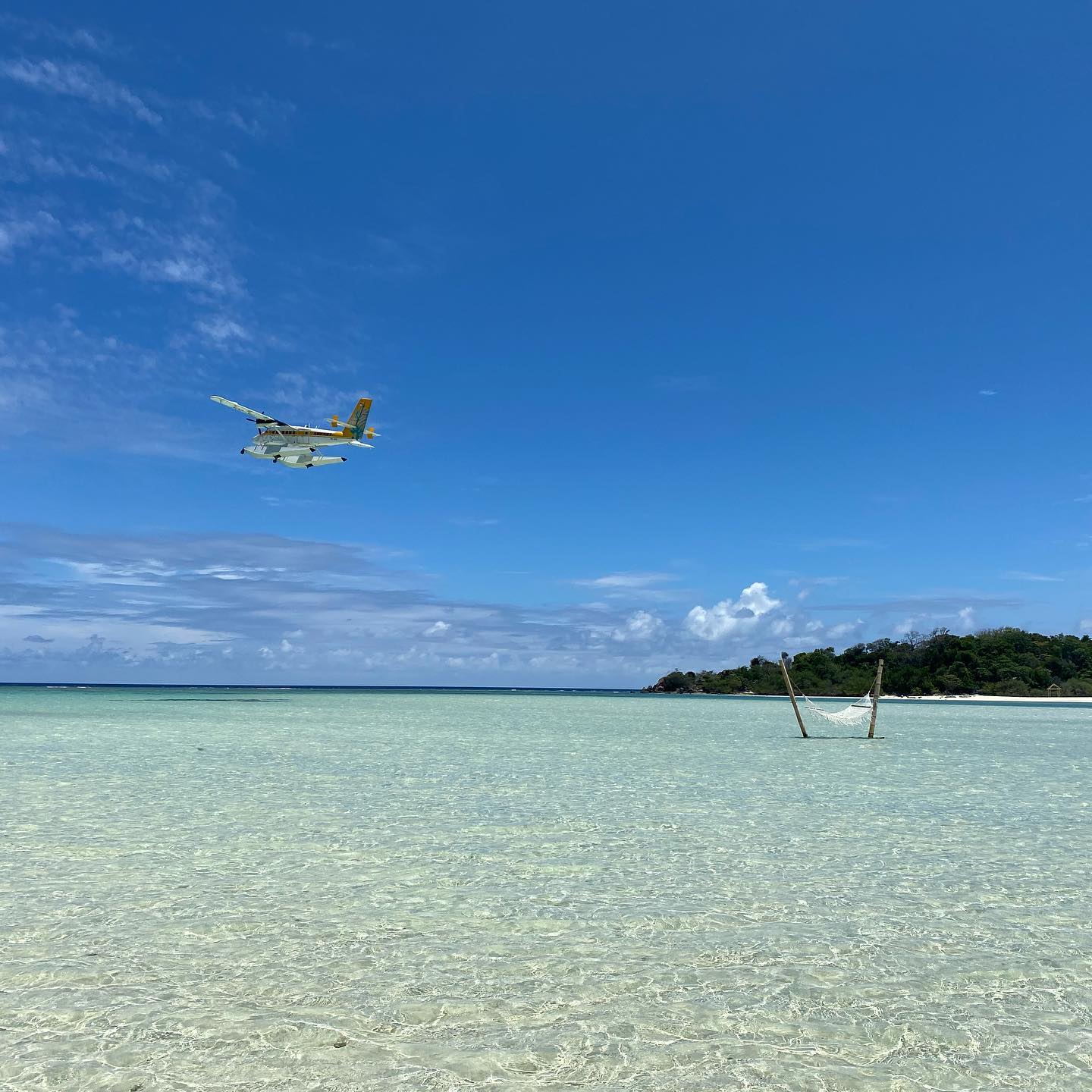 Seaplane flying over shallow water
