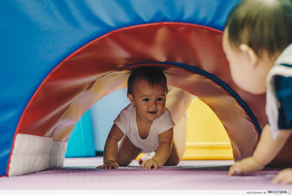 Infant crawling through a play tunnel
