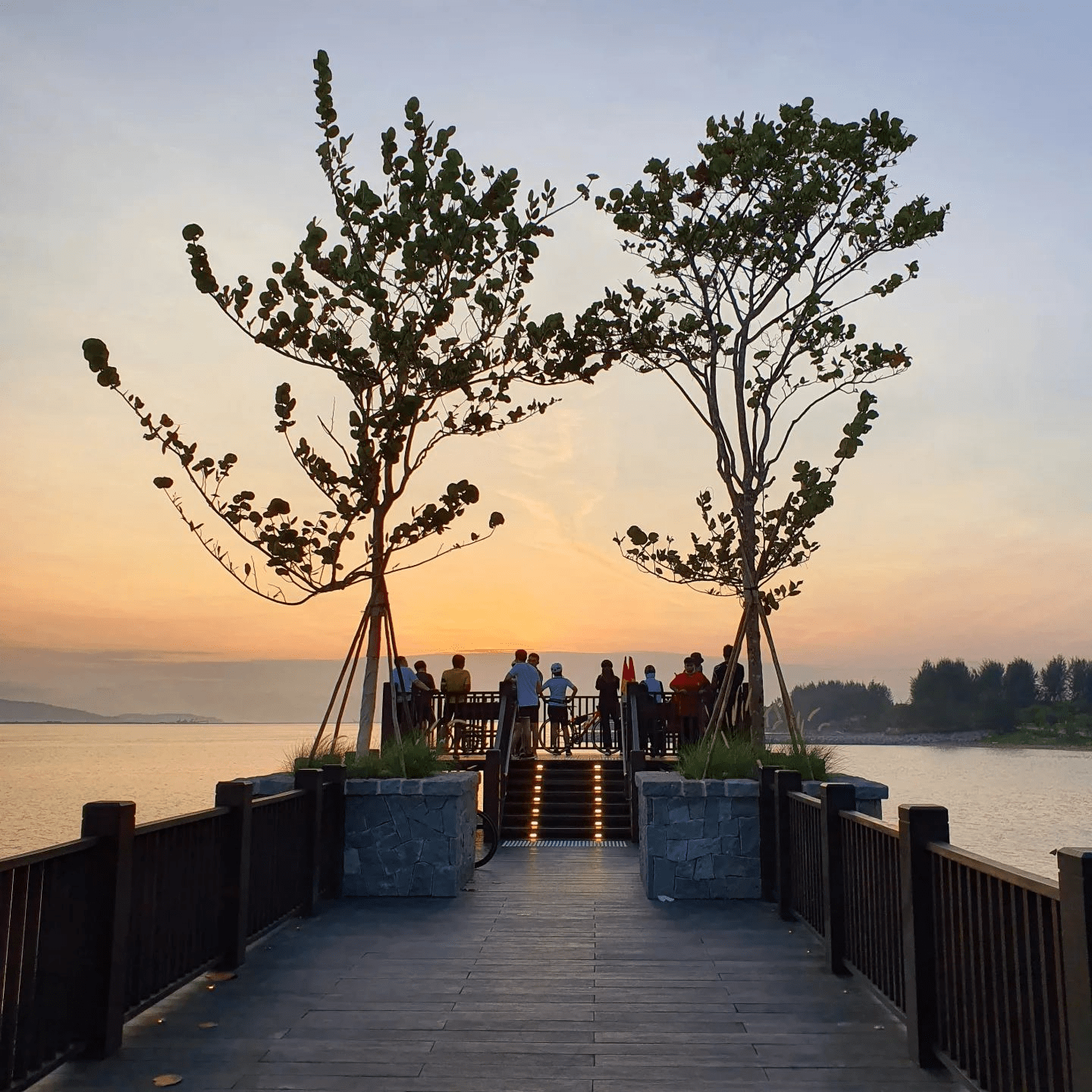 people standing at a dock watching the sunrise in Singapore