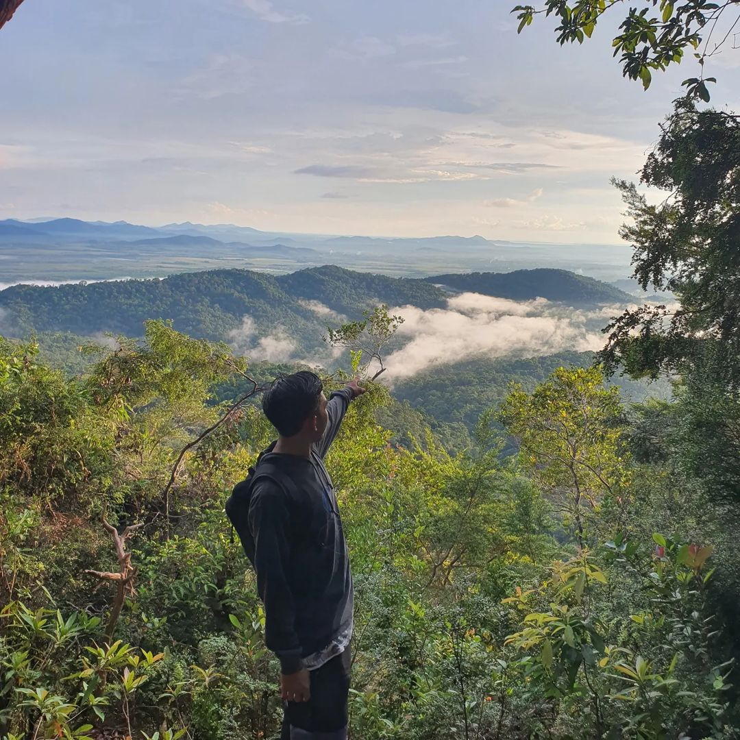 Easy hiking trails in Indonesia - Guy pointing at view from Gunung Tajam 