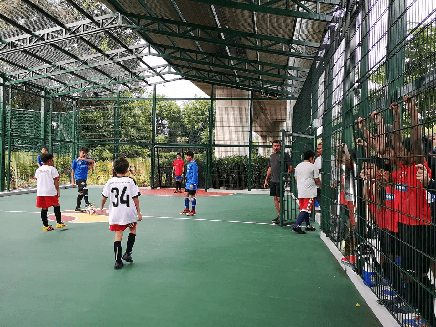 Futsal courts in SG - Kids playing at futsal court and others watching 