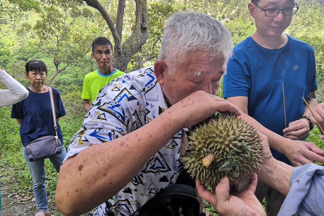 things to do penang - man tries durian 
