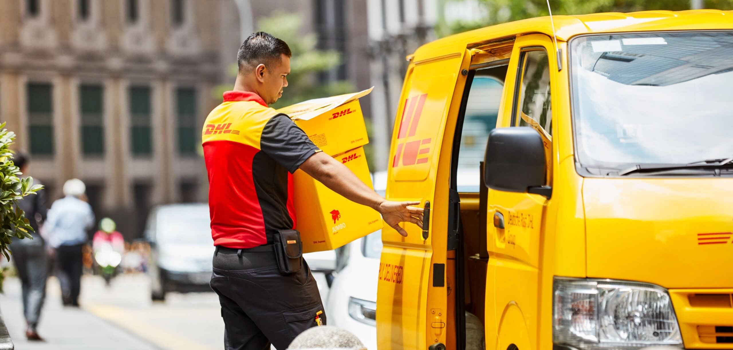 guy opening van door of a yellow dhl truck, courier services singapore