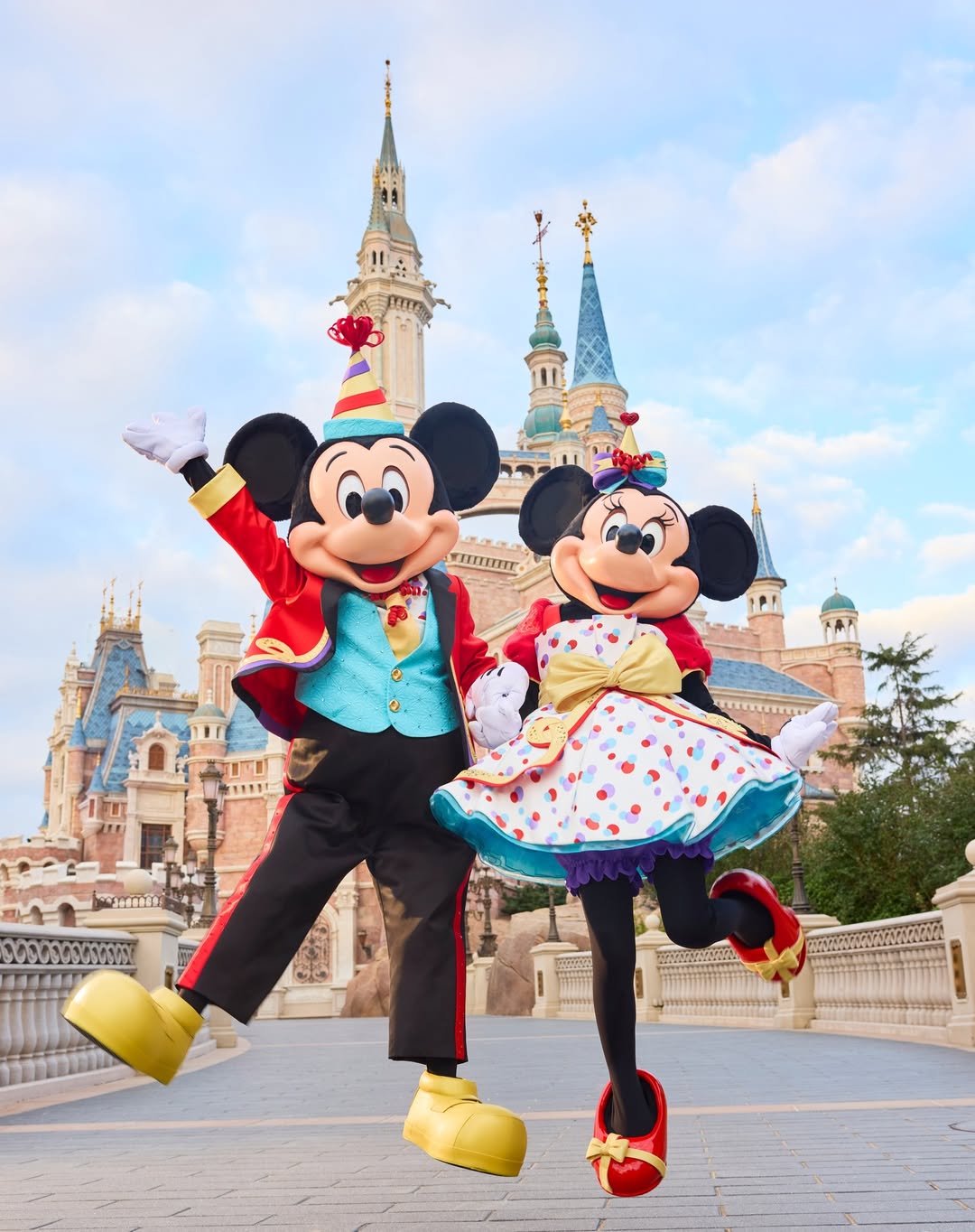 Mickey and Minnie Mouse posing in front of the princess castle at Disneyland