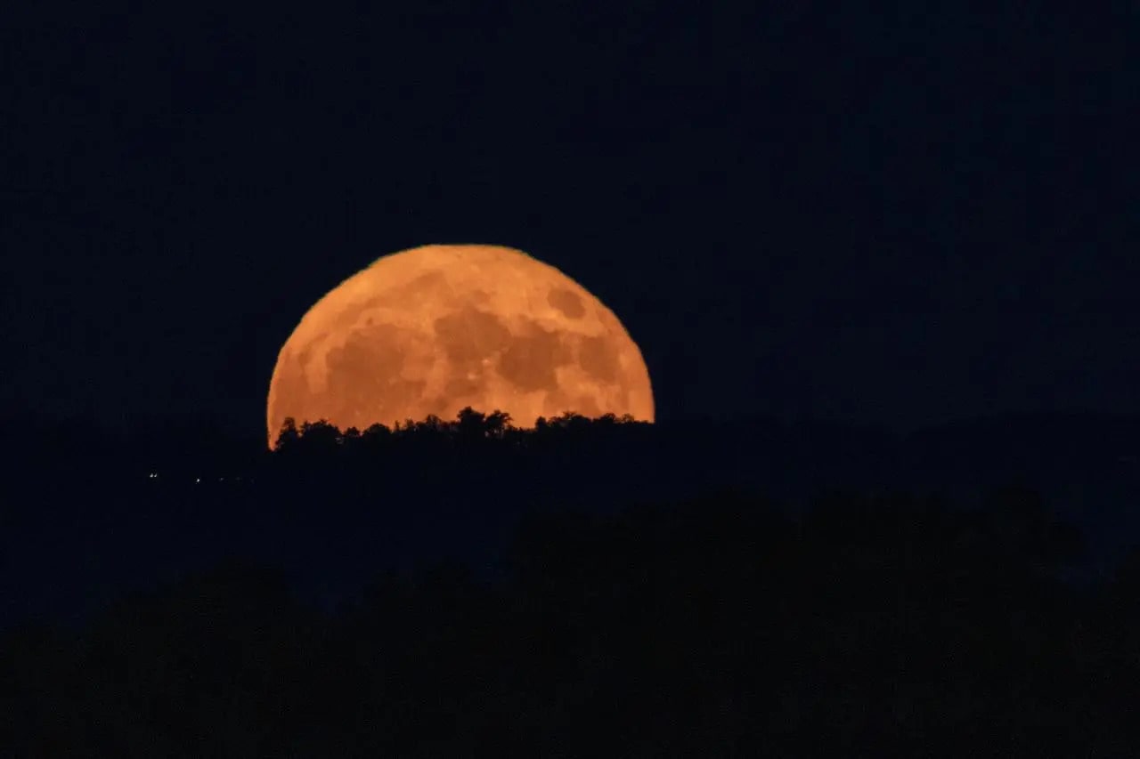 Beaver Moon partially covered by a mountain