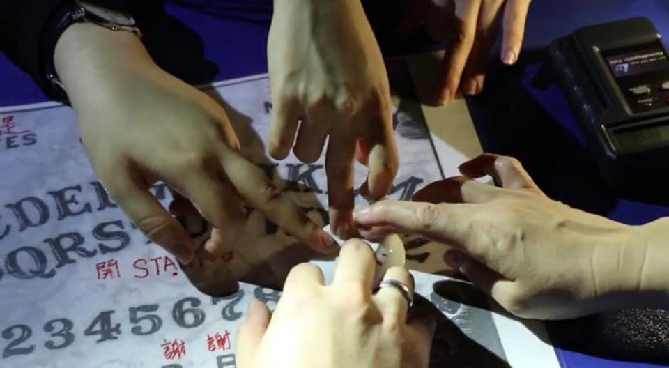 Ghost hunters attempting to communicate with spirits using an Ouija board