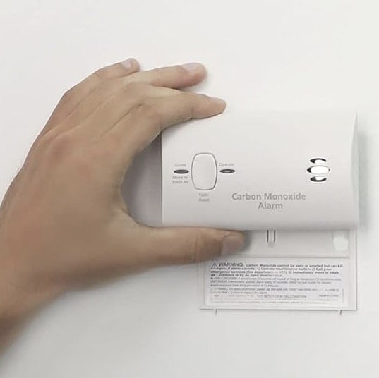 home fire - hand holding carbon monoxide detector