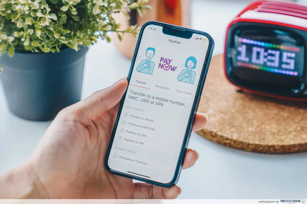 hand holding phone with paynow transaction